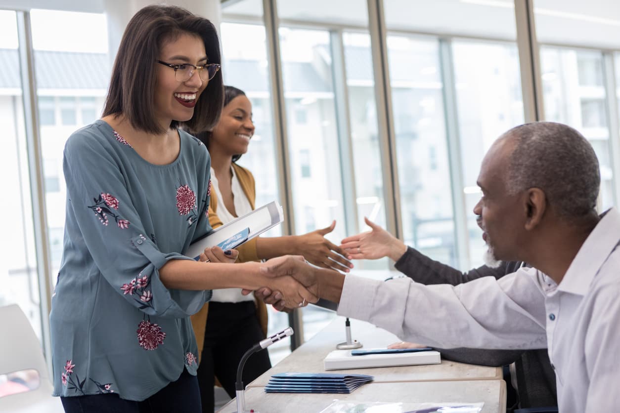 community meeting with two people shaking hands
